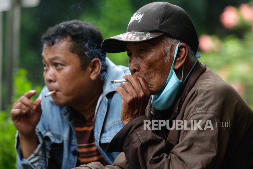  Ahmad (kanan), 80 tahun, merokok di sebuah jalan di Jakarta, 31 Mei 2021. Ahmad telah merokok sejak berusia 19 tahun, yang berarti ia telah merokok setiap hari selama kurang lebih 61 tahun. Data dari Southeast Asia Tobacco Control Alliance tahun 2016, Indonesia merupakan salah satu negara dengan populasi perokok terbesar di Asia Tenggara. 