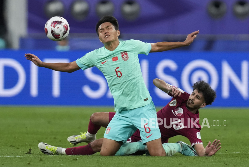 Pemain China Wang Shangyan (kiri) berebut bola dengan pemain Qatar Khalid Mazeed dalam pertandingan Grup A Piala Asia di Stadion Internasional Khalifa, Doha, Qatar, Senin (22/1/2024). Qatar menang 1-0