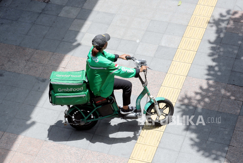 Pengemudi ojek daring mengendarai sepeda motor listriknya di Jakarta (ilustrasi).