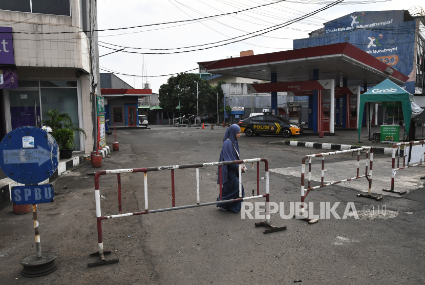 Seorang pejalan kaki melintas di depan SPBU yang ditutup sementara di Jalan Ir Juanda, Bekasi, Jawa Barat. Polisi menangkap 5 dalang viral BBM dicampur air di SPBU Bekasi, 3 sudah tersangka.