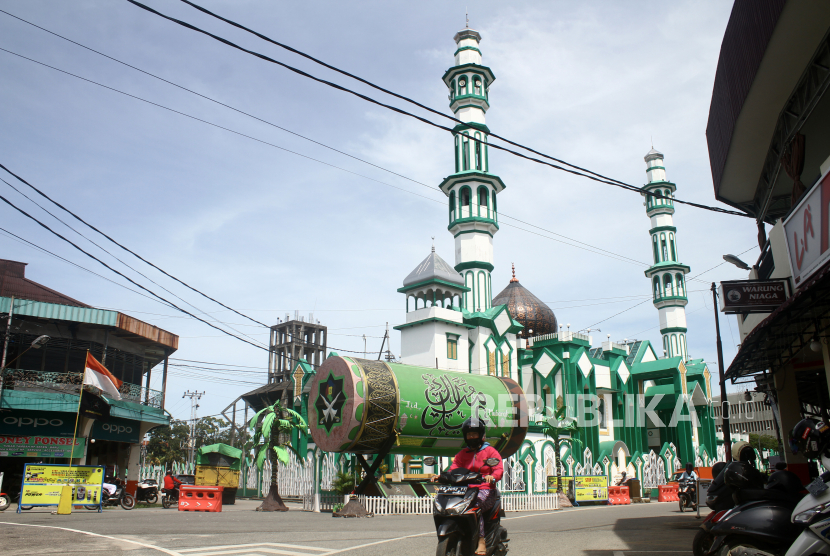 Sejumlah pengendara motor melintas di dekat Masjid Raya di Kota Singkawang, Kalimantan Barat, Jumat (12/11/2021). Masjid Raya Singkawang yang pertama kali didirikan pada tahun 1885 dan merupakan salah satu masjid tertua di Kalimantan Barat tersebut menjadi salah satu landmark kota di Singkawang. 