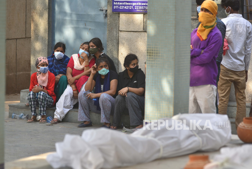 Anggota keluarga korban COVID-19 yang berduka di tempat kremasi di New Delhi, India, Kamis (29/4). Delhi melaporkan 25.986 kasus baru, 368 kematian dalam 24 jam terakhir dan terus berjuang dengan pasokan oksigen.