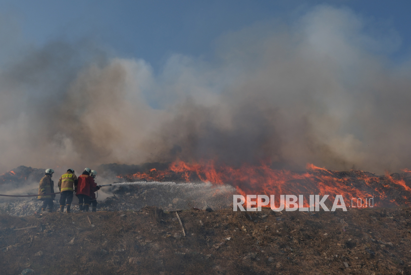 Petugas Badan Penanggulangan Bencana Daerah (BPBD) Kabupaten Badung berupaya memadamkan api yang terus menjalar saat terjadi kebakaran sampah di Tempat Pembuangan Akhir (TPA).