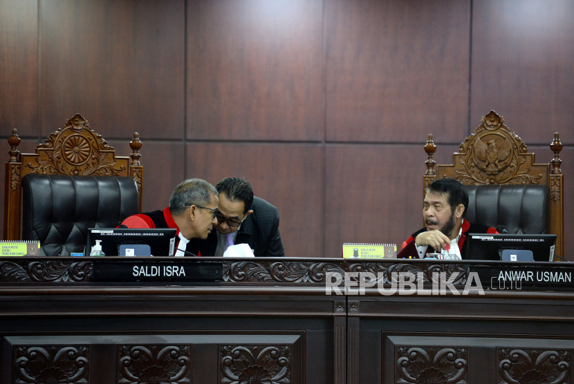 Ketu Majelis Hakim Mahkamah Konstitusi (MK) Anwar Usman (kanan) berbincang dengan Majelis Hakim MK Saldi Isra dalam sidang pembacaan putusan di Ruang Sidang Pleno Gedung MK, Jakarta, Senin (16/10/2023). Mahkamah Konstitusi (MK) menolak gugatan uji materi batas usia minimal calon presiden (capres) dan calon wakil presiden (cawapres) dalam Undang-Undang Nomor 7 Tahun 2017 tentang Pemilu yang diajukan oleh Partai Solidaritas Indonesia (PSI). MK menolak syarat usia capres-cawapres diturunkan menjadi 35 tahun. Dalam Sidang tersebut MK juga mengabulkan uji materi terhadap UU Nomor 7 Tahun 2017 tentang Pemilihan Umum terkait batas usia capres-cawapres yang diajukan mahasiswa UNS bernama Almas Tsaqibbirru Re A. MK menyatakan batas usia capres-cawapres tetap 40 tahun kecuali sudah berpengalaman sebagai kepala daerah. 