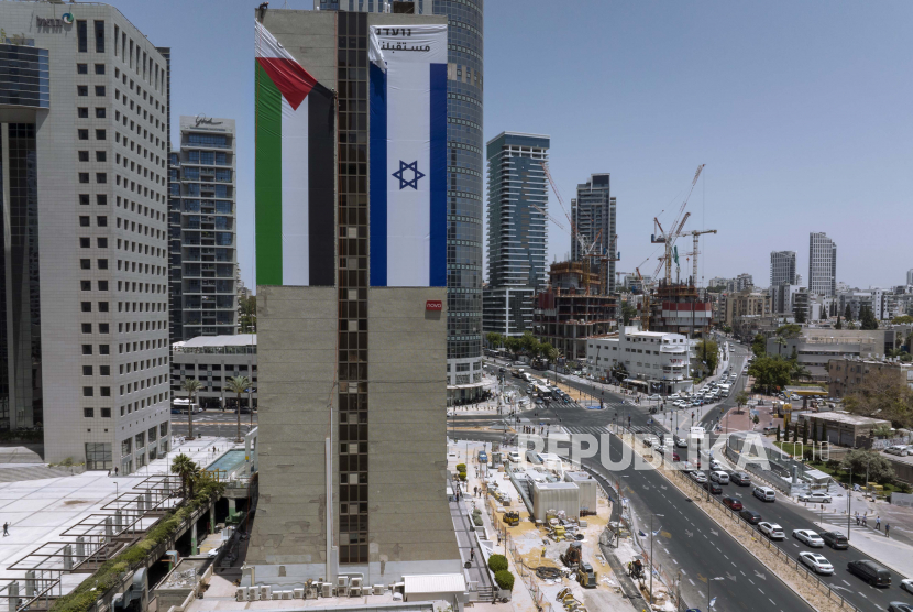  Bendera Palestina diturunkan dari sebuah gedung oleh otoritas Israel setelah dipasang oleh kelompok advokasi yang mempromosikan koeksistensi antara Palestina dan Israel, di Ramat Gan, Israel, Rabu, 1 Juni 2022.