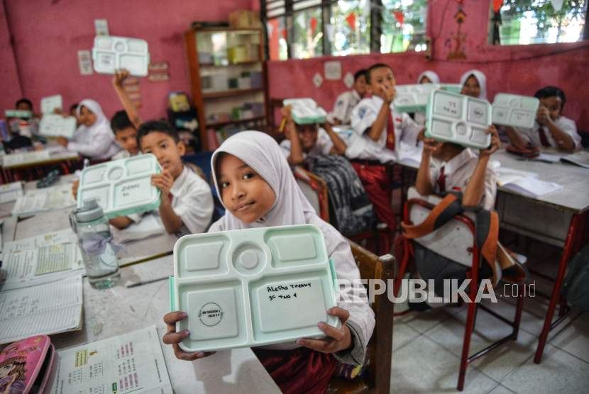 Para siswa menunjukan kotak makanan saat ujicoba pelaksanaan program Makan Bergizi Gratis (MBG) di SDN 4  Kota Tangerang, Banten, Senin (5/8/2024). Uji coba MBG tersebut bertujuan mematangkan strategi dan mitigasi program unggulan Presiden dan Wakil Presiden Terpilih periode 2024-2029. Adapun paket menu yang disediakan hari ini adalah Nasi Putih, Fuyunghai, Capcay, Melon dan Susu.