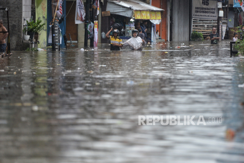 Warga melintas banjir yang mengenangi Jalan Kemang Utara IX, Jakarta, Kamis (4/1/2024). Musim hujan di Indonesia dipengaruhi Monsun Asia.