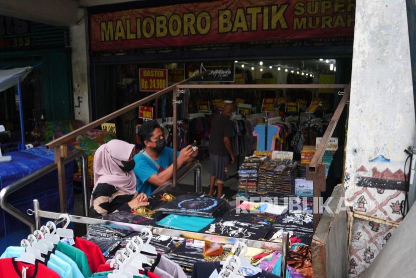 Pedagang melayani pembeli cenderamata di kawasan pedagang kaki lima Malioboro, Yogyakarta, Ahad (5/12). Pemerintah Daerah (Pemda) DIY bersama Pemerintah Kota (Pemkot) Yogyakarta berencana melakukan penataan pedagang kaki lima (PKL) yang berada di sepanjang trotoar Malioboro. Direncanakan, relokasi PKL Malioboro ini akan dilakukan pada awal 2022. Lokasi relokasi PKL Malioboro nantinya di eks gedung Bioskop Indra dan eks Gedung Dinas Pariwisata Yogyakarta.