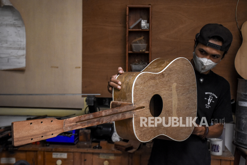Pekerja menyelesaikan pembuatan gitar di rumah produksi Secco Guitar, Jalan Tanjung, Bandung Wetan, Kota Bandung, Jawa Barat, Rabu (5/1).