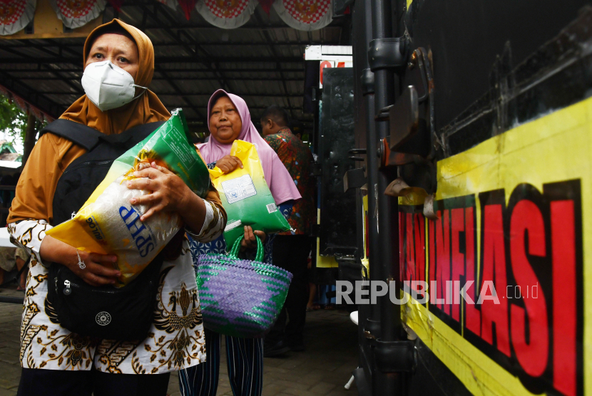 Warga membawa bahan kebutuhan pokok bersubsidi yang dibeli saat digelar Warung Tekan Inflasi (Wartek) di Kota Madiun, Jawa Timur, Kamis (14/3/2024).