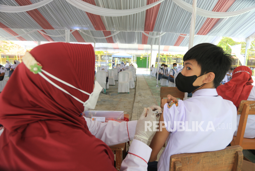 Vaksinator menyuntikkan vaksin COVID-19  kepada siswa saat vaksinasi massal di SMAN 2 Indramayu, Jawa Barat, Rabu (1/9/2021). Dinas Kesehatan kabupaten Indramayu melakukan percepatan vaksinasi COVID-19 massal bagi pelajar dengan target sekitar enam ribu orang yang bertujuan untuk persiapan Pembelajaran Tatap Muka (PTM). 