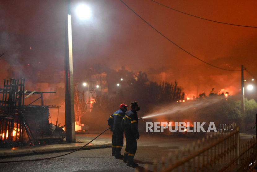Petugas pemadam kebakaran dan sukarelawan memadamkan api saat terjadi kebakaran hutan di desa Palagia, Alexandroupolis, Thrace, Yunani utara, Selasa (22/8/2023).