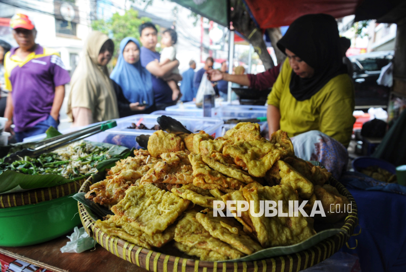 Pedagang melayani pembeli makanan untuk berbuka puasa di bazar takjil.