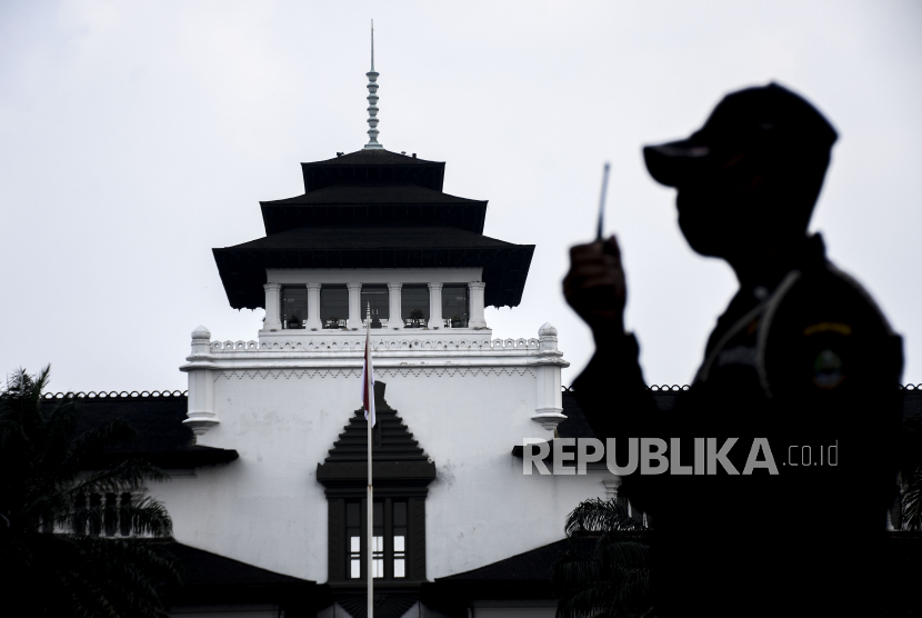 Petugas keamanan berjaga di kompleks Gedung Sate yang ditutup sementara di Jalan Diponegoro, Kota Bandung karena puluhan ASN terkonfirmasi positif Covid-19.  (ilustrasi)