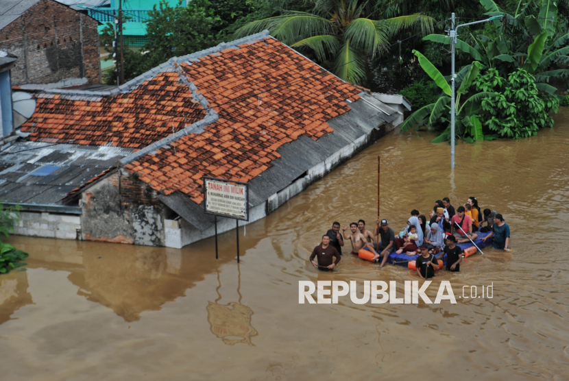 Petugas mengevakuasi warga saat banjir di kawasan Cililitan, Jakarta, Selasa (4/3/2025). Berdasarkan data BPBD DKI Jakarta mencatat, sebanyak 59 RT di kawasan Rawajati dan Cililitan terendam banjir dengan ketinggian mulai dari 30-300 centimeter yang disebabkan oleh meluapnya kali Ciliwung.