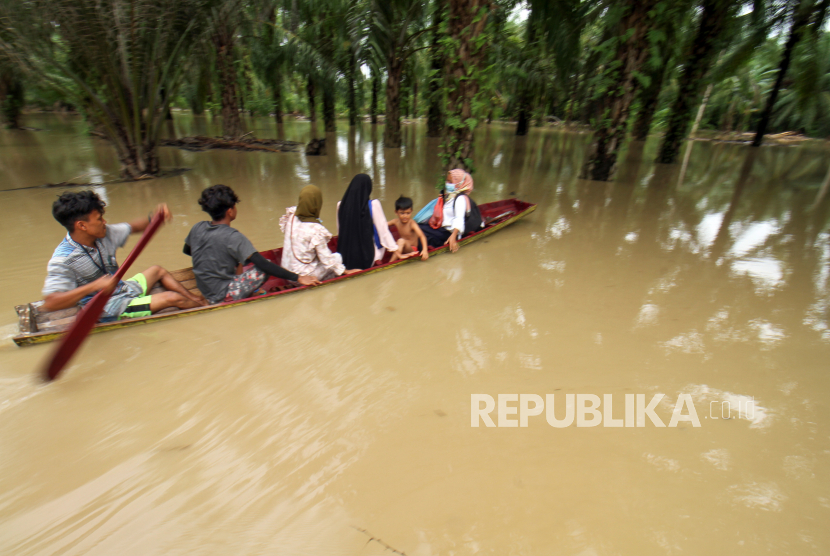 Warga menggunakan perahu keluar dari kepungan banjir di Desa Hagu, Kecamatan Matang Kuli, Aceh Utara, Aceh, Jumat (1/10/2021). Banjir yang disebabkan tingginya intensitas hujan hingga sejumlah tanggul sungai jebol itu merendam tujuh kecamatan di Aceh Utara dan dua kecamatan Kota Lhokseumawe dengan ketinggian air 1-2,5 meter. 