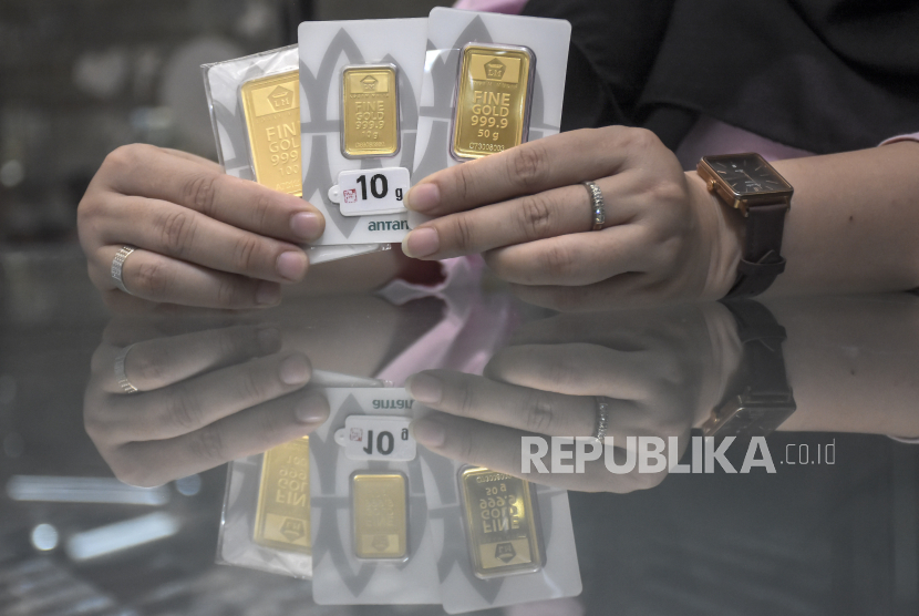 Karyawan menunjukkan emas batangan di salah satu toko emas dan perhiasan di Kota Bandung, Jawa Barat, Senin (16/10/2023). Harga emas batangan PT Aneka Tambang Tbk (Antam) tetap tinggi meski mengalami penurunan pada hari ini, Senin (16/10/2023). Untuk pecahan satu gram, emas batangan Antam dihargai Rp1.087.000 dari sebelumnya Rp1.088.000 per gram. Sementara harga pembelian kembali (buyback) tidak bergerak dan bertahan di level Rp969.000.