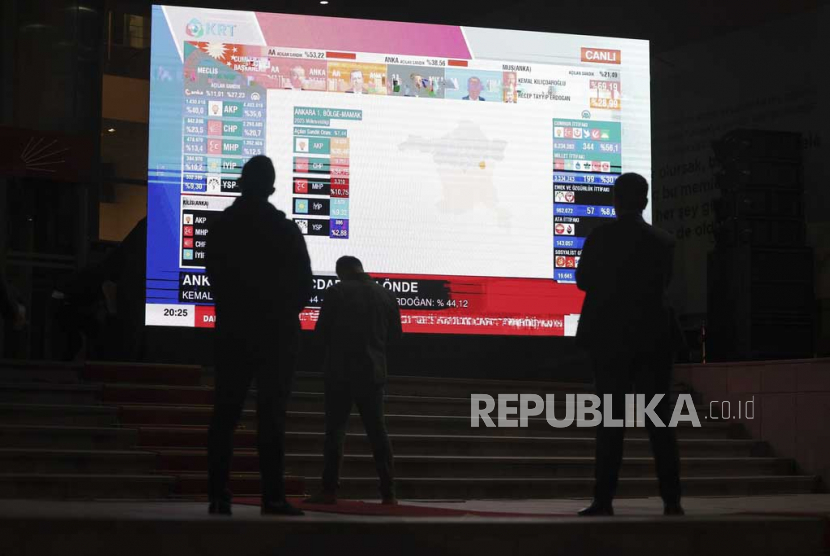Jurnalis menyaksikan hasil perhitungan cepat pemilu di markas besar Partai Rakyat Republik, CHP, di Ankara, Turki, Ahad, (14/5/2023).