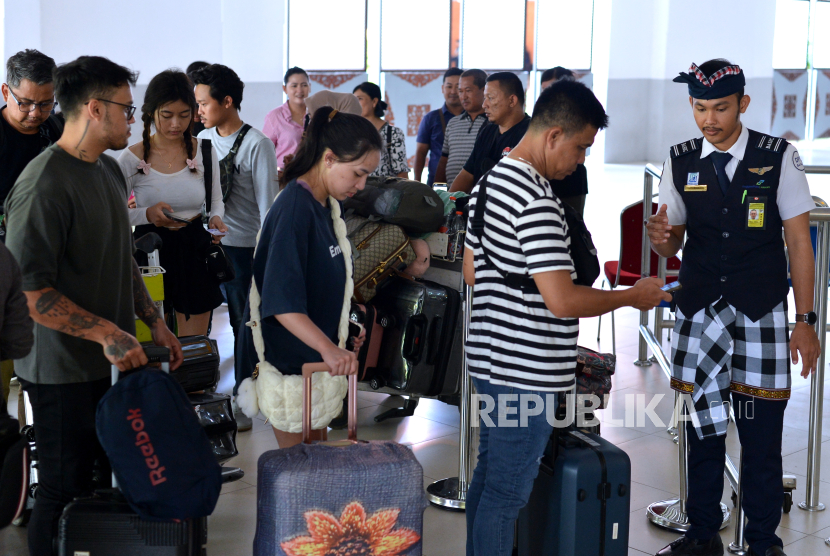 Petugas memeriksa tiket calon penumpang pesawat di Terminal Domestik Bandara Internasional I Gusti Ngurah Rai, Badung, Bali, Selasa (2/1/2024). Pengelola Bandara Bali memprediksi akan melayani sebanyak 69.436 orang penumpang penerbangan rute domestik dan internasional saat puncak arus balik liburan tahun baru pada Selasa (2/1). 