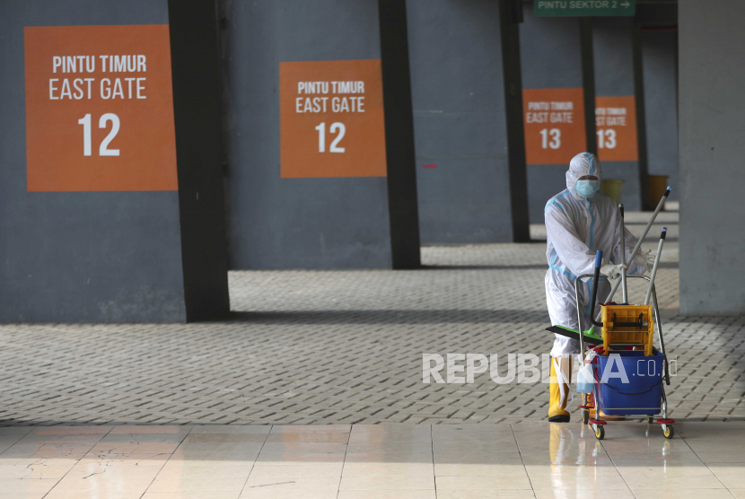  Seorang pekerja yang mengenakan pakaian pelindung berjalan di luar fasilitas karantina untuk orang-orang yang menunjukkan gejala COVID-19 di tengah wabah virus corona di Stadion Patriot Candrabhaga di Bekasi di pinggiran Jakarta, Indonesia, Senin, 28 September 2020.