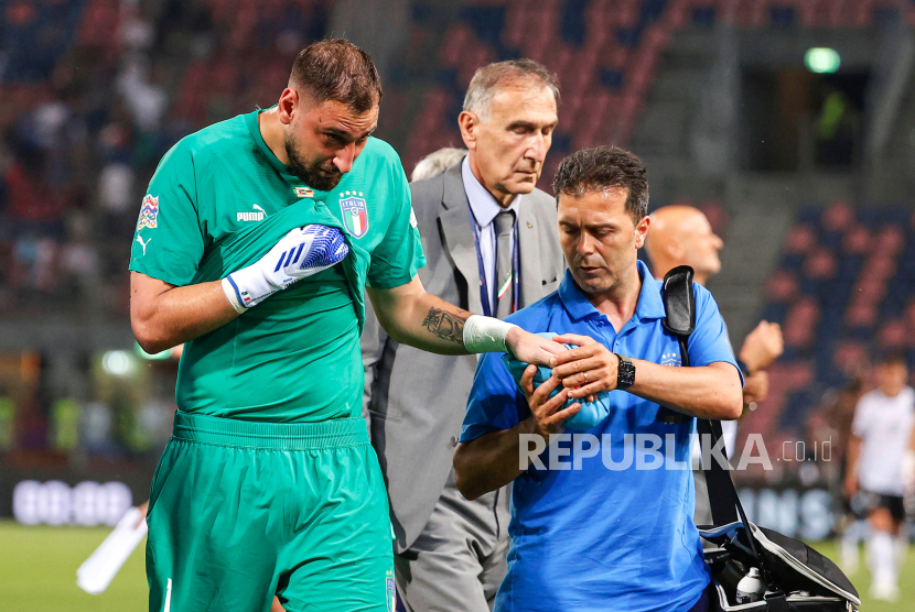 Penjaga gawang Italia Gianluigi Donnarumma (kiri) menerima bantuan medis setelah pertandingan sepak bola UEFA Nations League antara Italia dan Jerman di Stadion Renato Dall'Ara, Bologna, Ahad (5/6/2022) dini hari WIB.