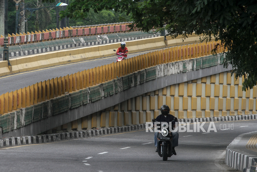 Sejumlah pengendara melintas dengan kondisi jalan yang terlihat lengan di Pekanbaru, Riau, Selasa (14/4/2020). Penerapan Pembatasan Sosial Berskala Besar (PSBB) dalam rangka mengatasi wabah virus Corona (COVDI-19) di Kota Pekanbaru direncanakan akan dimulai pada 17 April 2020 dan berlangsung selama 15 hari kedepan