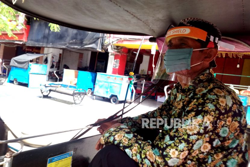 Kusir menggunakan pelindung wajah menunggu penumpang di Malioboro, Yogyakarta.  Menyambut normal baru pandemi Covid19, andong wisata di Jogja ikut berbenah