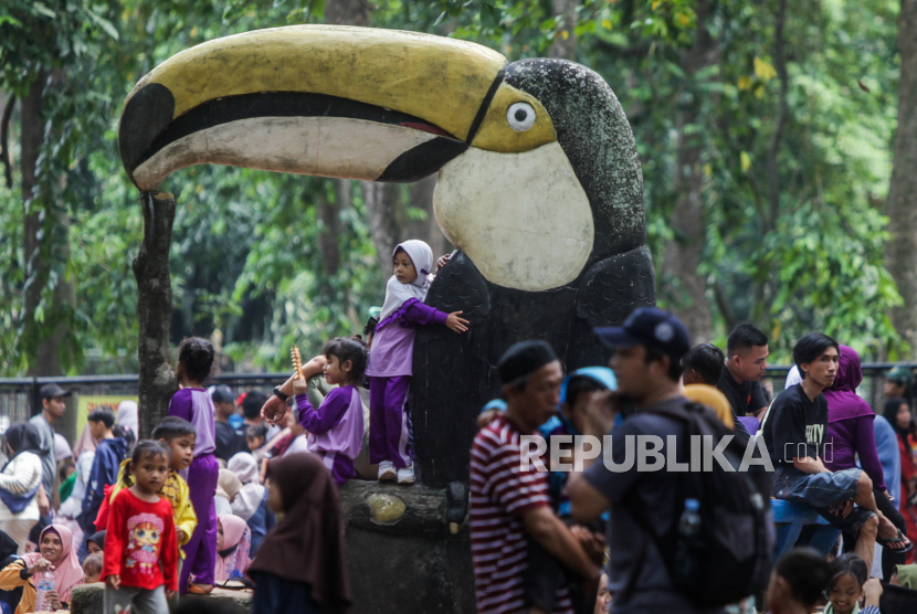 Pengunjung beristirahat di patung burung saat berwisata di Taman Margasatwa Ragunan, Pasar Minggu, Jakarta Selatan, Senin (25/12/2023).