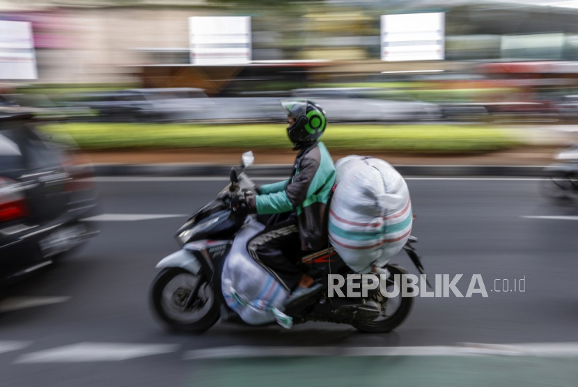 Pengemudi ojek online mengendarai motornya di jalanan ramai di Jakarta, 11 Desember 2023.
