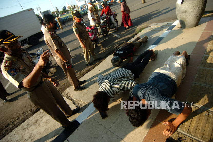 Anggota Satpol PP memberikan hukuman kepada warga push up saat razia masker (ilustrasi)