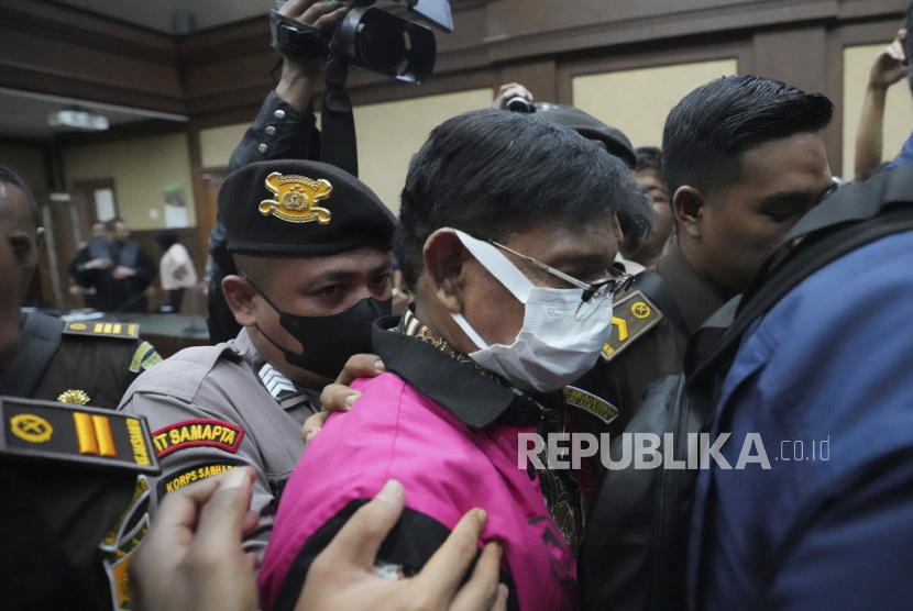 Former Indonesian Communication and Information Minister Johnny G. Plate, center, is escorted by prosecutors and police after his trial at an anti-graft court in Jakarta, Indonesia, Tuesday, June 27, 2023. Indonesia