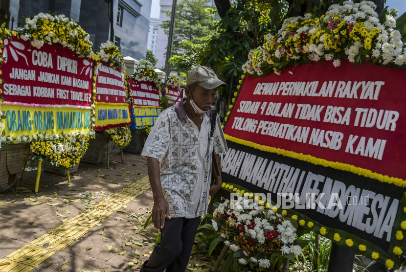 Warga melintasi karangan bunga di Pengadilan Tipikor, Jakarta, Rabu (3/6/2020). Karangan bunga tersebut berasal dari korban terdampak kasus asuransi Jiwasraya yang mengharapkan lembaga terkait untuk memberikan keadilan bagi mereka. (ilustrasi)