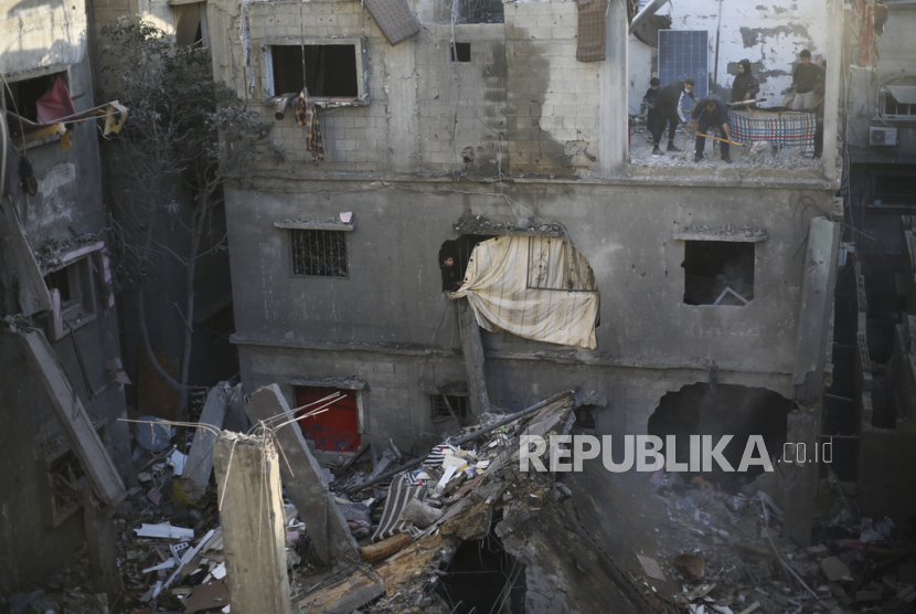 Warga Palestina melakukan pembersihan setelah rumahnya terkena serangan Israel di Rafah, Jalur Gaza, Ahad, 24 Desember 2023.