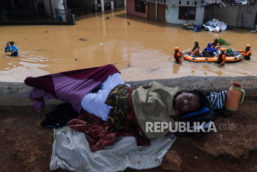 Warga tidur di tempat yang aman dari banjir saat relawan dari Dompet Dhuafa mengevakuasi warga di Cipinang Melayu, Jakarta Timur, Jumat (19/2/2021). Banjir di kawasan tersebut akibat curah hujan yang tinggi dan meluapnya air dari Kali Sunter. 