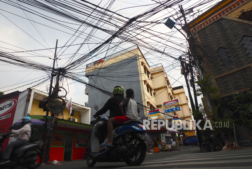  : Suasana persimpangan Jl Kiai H Syahdan - Rawa Belong 2 dengan latar kabel utilitas internet yang semrawut. Legislator meminta Pemprov DKI untuk memberi kompensasi kepada korban kabel optik.