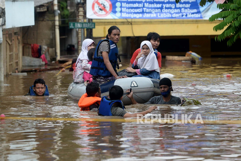 Petugas menggunakan perahu karet mengevakuasi warga dengan melewati banjir yang merendam di kawasan Rawajati Kalibata, Kecamatan Pancoran, Jakarta Selatan, Senin (8/2).