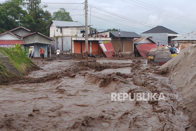 Sejumlah warga menyaksikan banjir lahar dingin menerjang kawasan pemukiman di Nagari Bukik Batabuah, Kecamatan Canduang, Agam, Sumatra Barat, Jumat (5/4/2024).