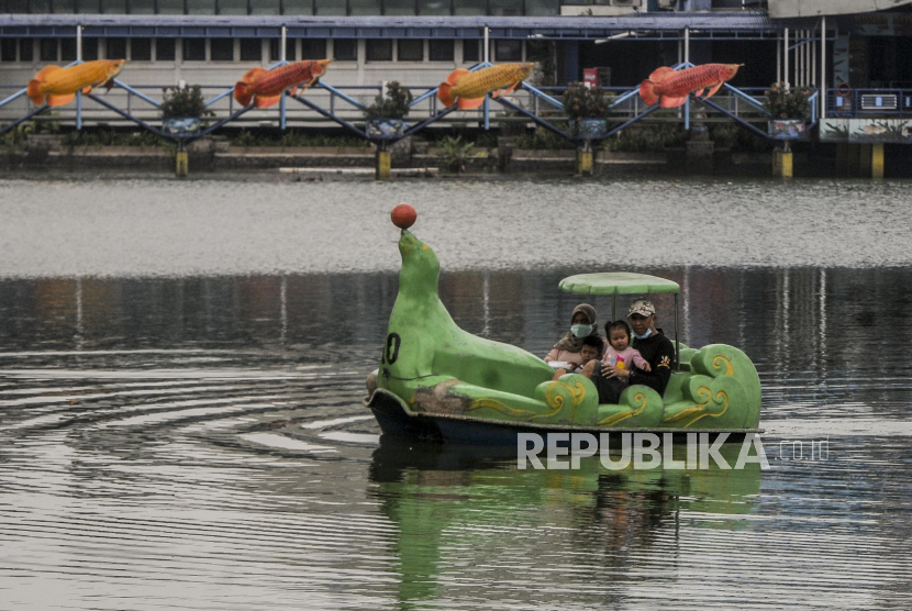Sejumlah pengunjung menaiki perahu saat berwisata di Taman Mini Indonesia Indah (TMII) Jakarta, Sabtu (24/10). Sejak beroperasi pada PSBB transisi kedua, TMII hanya dikunjungi sekitar 1.000 orang pada hari biasa dan 3.000 hingga 7.000 orang pada akhir pekan. Jumlah tersebut masih jauh dari kapasitas maksimal 25 persen berkisar 15.000 sampai 20.000 orang yang diduga akibat faktor masih tingginya angka penularan Covid-19. Republika/Putra M. Akbar