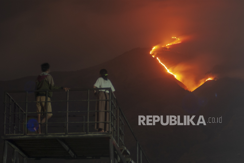 Warga melihat kebakaran Gunung Merbabu di Jlarem, Gladagsari, Boyolali, Jawa Tengah, Sabtu (28/10/2023).  Balai Taman Nasional Gunung Merbabu menutup semua jalur pendakian Gunung Merbabu akibat terjadinya kebakaran hutan dan lahan di wilayah tersebut. 