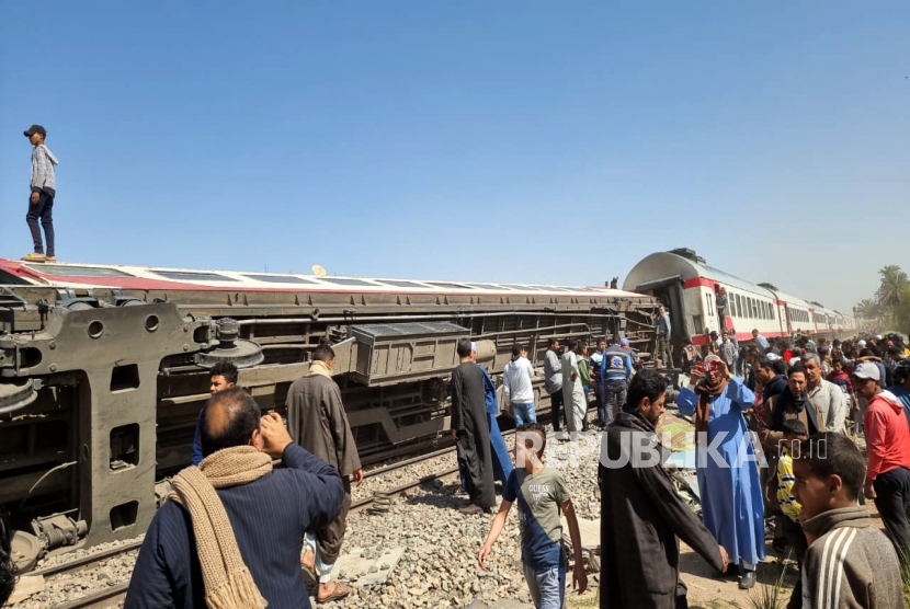  Orang-orang memeriksa lokasi kecelakaan kereta api di provinsi Sohag, Mesir, 26 Maret 2021. Menteri Perhubungan Mesir pada Senin (25/7/2022), mengumumkan tarif baru kereta api mulai bulan depan.