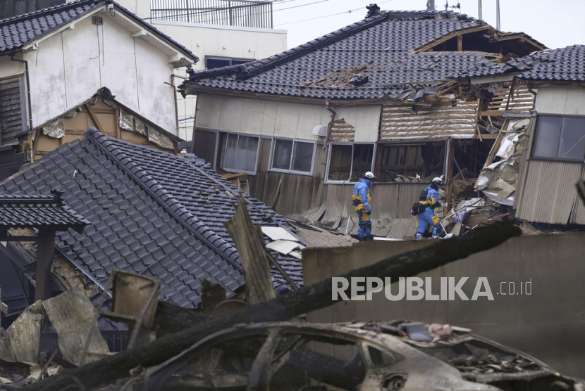Petugas polisi melakukan operasi pencarian di rumah yang hancur akibat gempa bumi di Wajima, prefektur Ishikawa, Jepang Selasa, (2/2/2024).