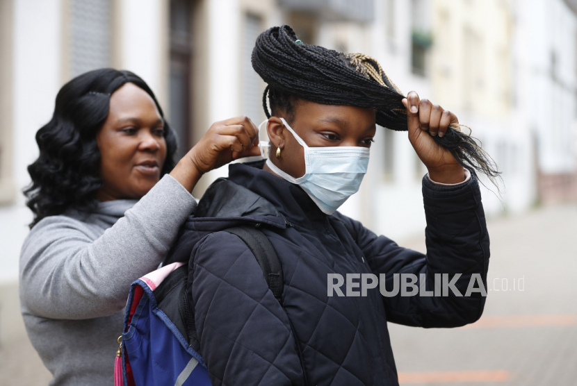 Seorang Ibu memasangkan masker putrinya sebelum masuk sekolah. Para siswa di beberapa sekolah di Belgia kembali bersekolah dengan mengenakan masker. Ilustrasi.