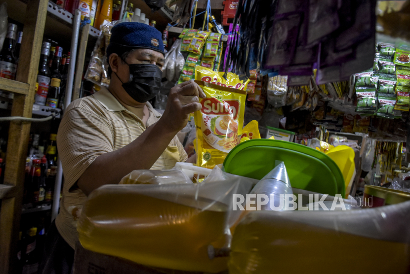 Pedagang menata minyak goreng kemasan dan curah yang dijual di kiosnya di pasar pada Senin (24/1/2022). Pedagang makanan di Gorontalo mengeluhkan harga minyak goreng yang belum turun di pasar.