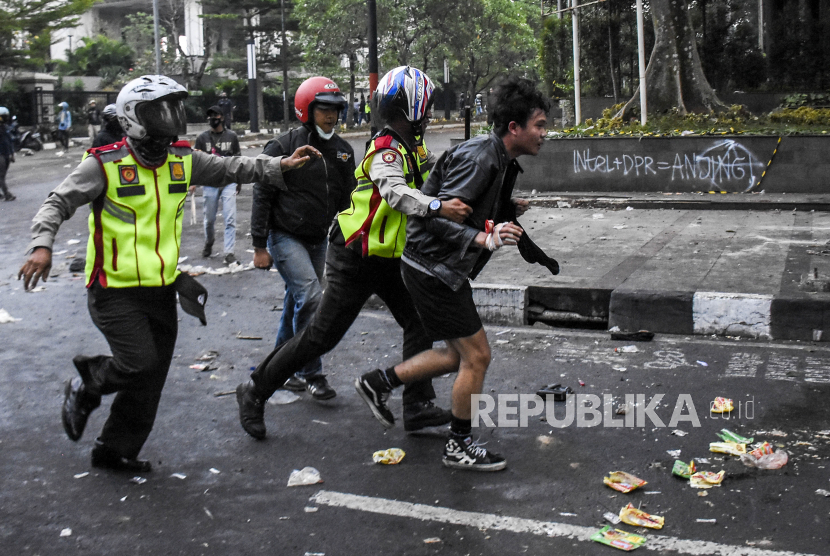 Petugas kepolisian menangkap demonstran saat unjuk rasa menentang UU Cipta Kerja di Jalan Diponegoro, Kota Bandung, Kamis (8/10).