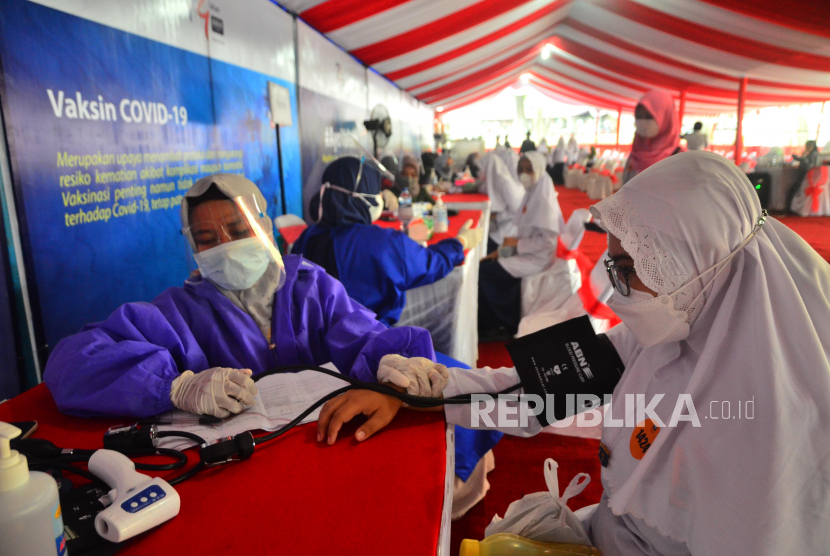 Tenaga kesehatan mengecek tekanan darah seorang pelajar saat mengikuti vaksinasi massal COVID-19 di Kudus, Jawa Tengah. 