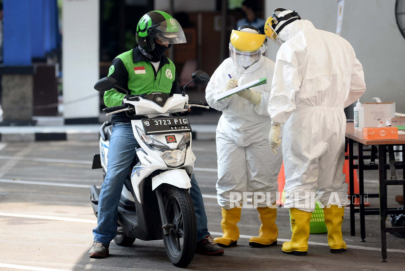 Pengemudi Gojek mengikuti Drive Thru Rapid Test Covid-19 di halaman kantor Kementerian Perhubungan, Jakarta.  Lembaga Demografi FEB UI melakukan riset apakah pandemi Covid-19 berpengaruh terhadap penghasilan para pengemudi tersebut selama Maret hingga April 2020.  