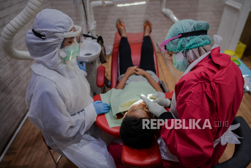 Petugas kesehatan memeriksa gigi seorang anak di klinik gigi Medikids by MHDC Green Terrace kawasan Ceger, Cipayung, Jakarta, Selasa (7/7). Pada masa PSBB transisi menuju tatanan normal baru sejumlah protokol kesehatan di terapkan di klinik tersebut seperti penggunaan pakaian alat pelindung diri, menggunakan pelindung wajah, serta diwajibkan menggunakan masker diarea klinik.