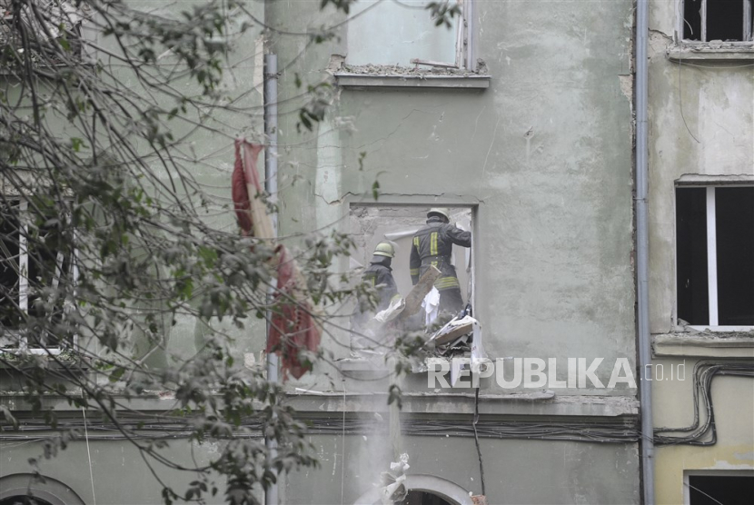 Tim penyelamat Ukraina bekerja di lokasi ruangan bangunan setelah roket menghantam sebuah blok apartemen di Lviv, Ukraina, Kamis (6/7/ 2023). 