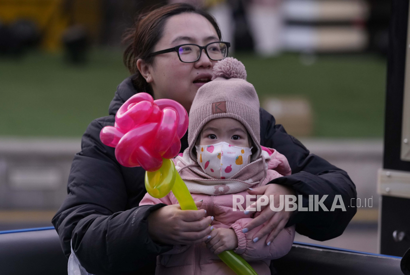 Seorang anak yang mengenakan masker untuk mencegah penyebaran virus corona mengunjungi sebuah mal di Beijing, China. Penelitian terbaru menemukan biaya membesarkan anak di China tujuh kali lipat dari PDB per kapita, jauh lebih tinggi dari Amerika Serikat (AS) dan Jepang.