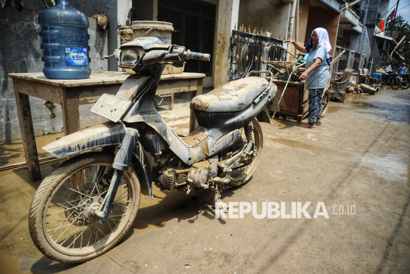 Warga membersihkan lumpur sisa banjir di Perumahan Pondok Gede Permai, Bekasi, Jawa Barat, Rabu (5/3/2025). Banjir dikawasan tersebut sudah surut dan menyisakan lumpur berwarna kecoklatan di jalan dan rumah-rumah warga. Sebagian warga mulai membersihkan sisa-sisa lumpur di rumah mereka. Menurut petugaa banjir di kawasan Pondok Gede Permai mulai surut pada Rabu (5/3/2025) dini hari, pada pukul 01.00 WIB. Sebelumnya, banjir di titik ini jadi salah satu yang terparah dengan ketinggian air mencapai 3 meter.